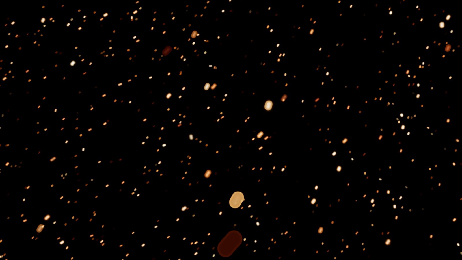Big embers in front of the lens, blurred into bokeh discs by the camera