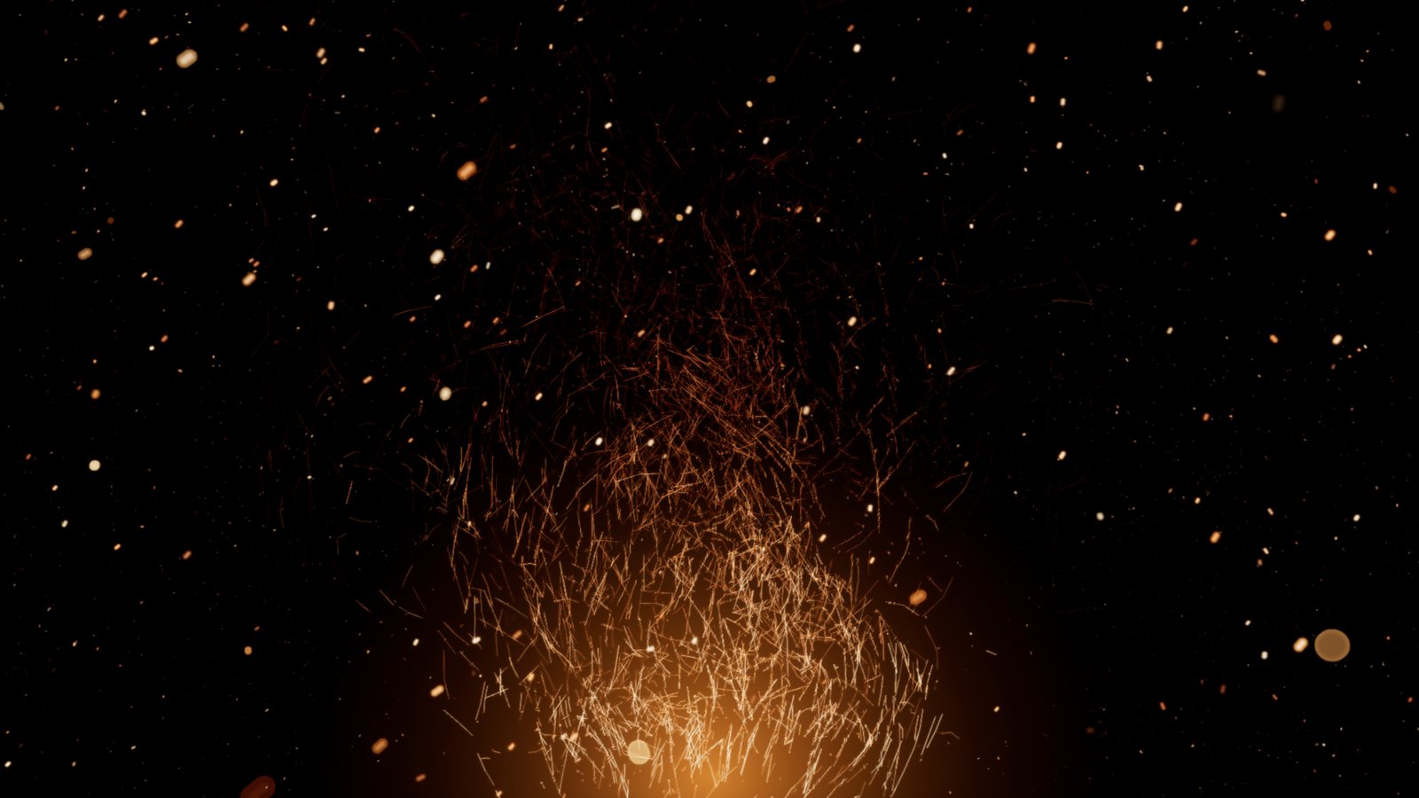 A blaze of fine ember streaks with drifting embers and bokeh all around, on black